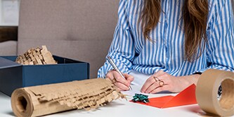 Kobieta starannie pakująca prezent przy użyciu folii Scotch™ Cushion Lock™
